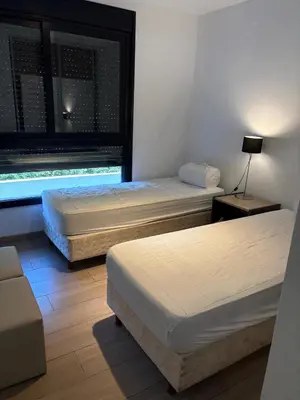 two beds in a room with a window at Complejo Las Pircas Alta Gracia in Alta Gracia