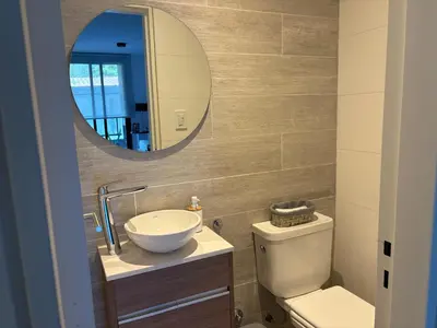 a bathroom with a sink and a toilet and a mirror at Complejo Las Pircas Alta Gracia in Alta Gracia