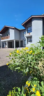 a building with yellow flowers in front of it at departamento al pie de las sierras in Villa General Belgrano