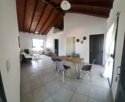 a living room with a table and chairs at departamento al pie de las sierras in Villa General Belgrano
