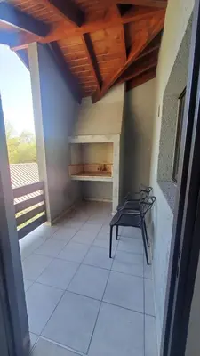 a room with a bench and a table on a porch at departamento al pie de las sierras in Villa General Belgrano