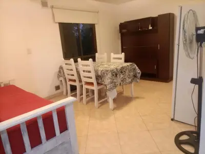 a dining room with a table and chairs in a room at Departamento en Villa Carlos Paz in Villa Carlos Paz