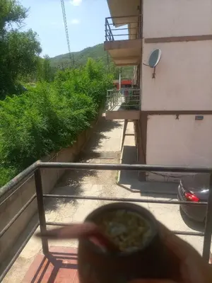a person holding a bowl of food on a balcony at Departamento en Villa Carlos Paz in Villa Carlos Paz