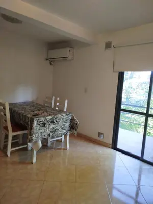 a dining room with a table and chairs and a window at Departamento en Villa Carlos Paz in Villa Carlos Paz
