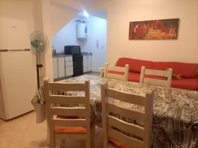 a living room with a table and chairs and a couch at Departamento en Villa Carlos Paz in Villa Carlos Paz