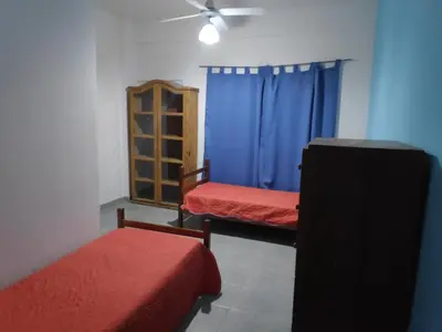 a room with two beds and a blue curtain at Alquileres centro Mina Clavero in Mina Clavero
