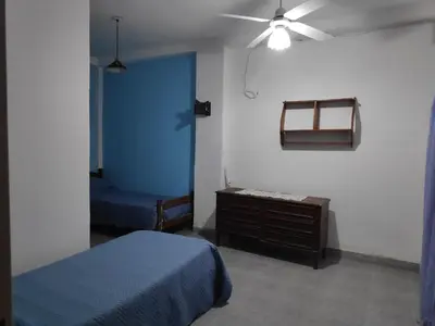 a bedroom with a blue bed and a wooden dresser at Alquileres centro Mina Clavero in Mina Clavero