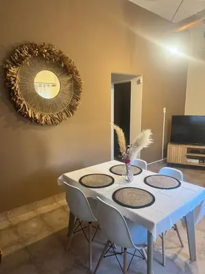 a white table with chairs and a mirror on the wall at Casa Tati in Santa Rosa de Calamuchita