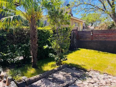 a yard with a fence and a palm tree at Casa Tati in Santa Rosa de Calamuchita