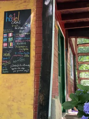 a chalkboard sign on the side of a building at HOSTEL CASA C Alojamiento, Coworking y Centro Cultural in Villa General Belgrano