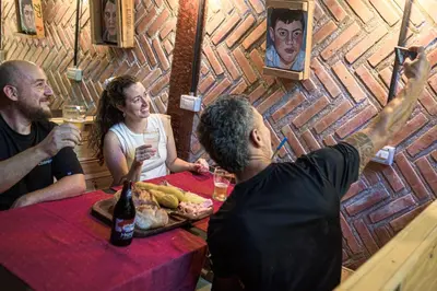 a group of people sitting at a table with drinks at HOSTEL CASA C Alojamiento, Coworking y Centro Cultural in Villa General Belgrano
