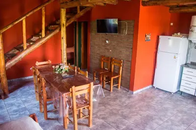 a kitchen with a table and chairs and a refrigerator at Complejo Fra Noi in Villa Anizacate