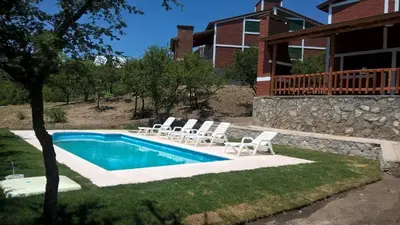a swimming pool with lounge chairs and a house at Complejo Fra Noi in Villa Anizacate