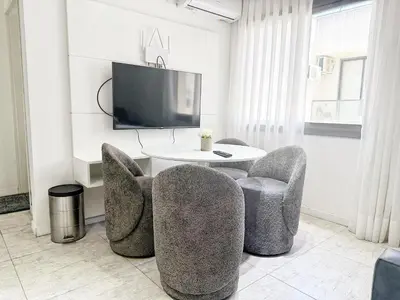 a living room with two chairs and a table and a tv at Edificio Lake Tower in Villa Carlos Paz