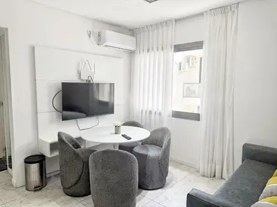 a living room with a table and chairs and a tv at Edificio Lake Tower in Villa Carlos Paz
