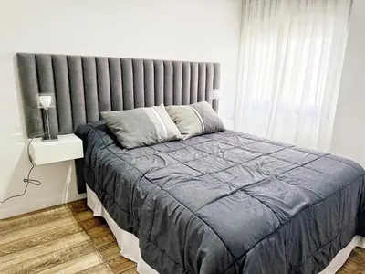 a bedroom with a large bed and a window at Edificio Lake Tower in Villa Carlos Paz