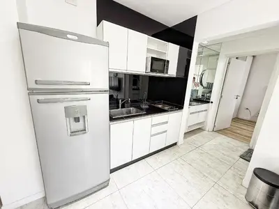 a white kitchen with a refrigerator and a sink at Edificio Lake Tower in Villa Carlos Paz