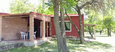 a red brick house with a table and chairs on a porch at Cabañas La Morada in Nono