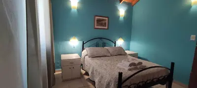 a bedroom with blue walls and a bed with towels on it at Cabañas La Morada in Nono