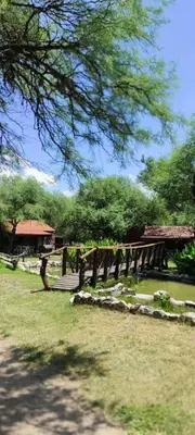 a park with a wooden bridge in the grass at Cabañas La Morada in Nono