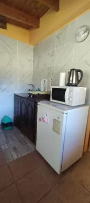 a kitchen with a microwave on top of a refrigerator at Cabañas La Morada in Nono