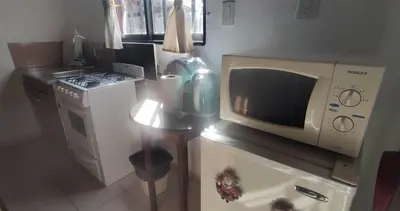 a kitchen with a microwave and a stove at Cabañas La Morada in Nono