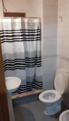 a bathroom with a black and white shower curtain and a toilet at Super Depto Balcarce 455 in Cordoba