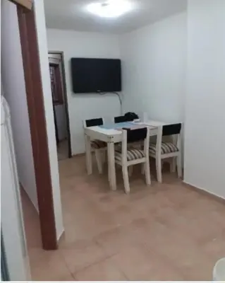 a dining room with a table and chairs and a television at Super Depto Balcarce 455 in Cordoba
