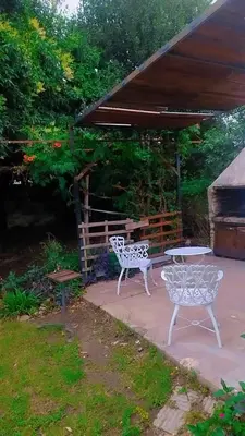 two white chairs and a table on a patio at Casa hasta 5 personas in Villa Carlos Paz