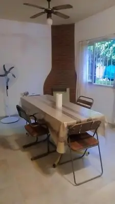 a large wooden table with chairs and a ceiling fan at Casa hasta 5 personas in Villa Carlos Paz