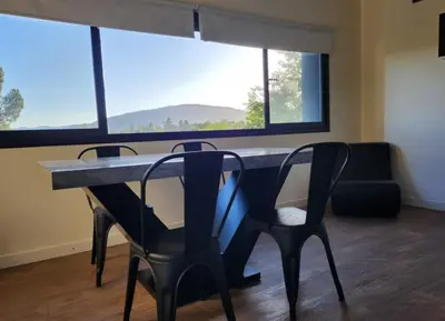 a table with two chairs in a room with a large window at Quadro Departamentos in Villa Carlos Paz