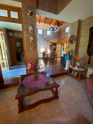 a large living room with a table in the middle at Chalet espectacular in Villa Carlos Paz