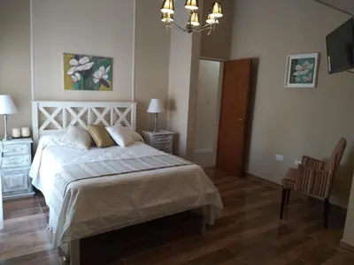 a bedroom with a bed and a television in it at Chalet privado hasta 8 personas con pileta in La Cuesta