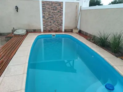 a swimming pool with blue water in a backyard at Chalet privado hasta 8 personas con pileta in La Cuesta
