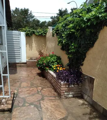 a garden with flowers and plants on the side of a building at Chalet privado hasta 8 personas con pileta in La Cuesta