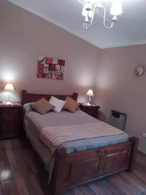 a bedroom with a large bed with two night stands at Chalet privado hasta 8 personas con pileta in La Cuesta