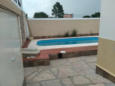 a swimming pool in front of a house at Chalet privado hasta 8 personas con pileta in La Cuesta