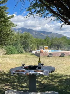 a picnic table with a bottle of wine and glasses at La Emilia in Las Rabonas