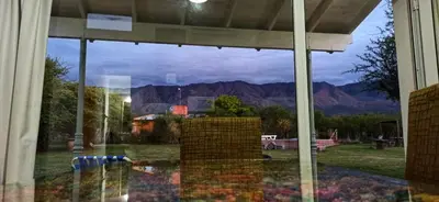a window of a house with a view of the mountains at La Emilia in Las Rabonas