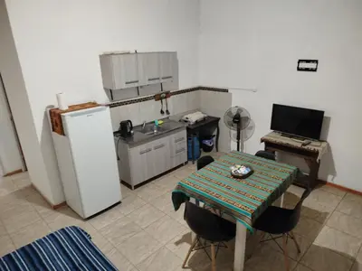 a small kitchen with a table and a refrigerator at Cabaña los cuates in Villa Ciudad Parque