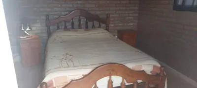 a wooden bed in a room with a brick wall at casa balcon del sol in Villa Carlos Paz