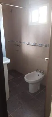 a bathroom with a white toilet and a sink at casa balcon del sol in Villa Carlos Paz