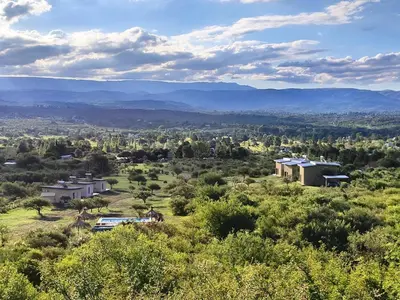 a house on a hill with mountains in the background at Complejo MASVISTA in San Antonio de Arredondo