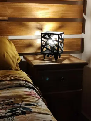 a lamp on a night stand next to a bed at Complejo MASVISTA in San Antonio de Arredondo