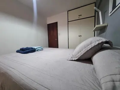 a bedroom with a large white bed with two pillows at Chacabuco Confort - Bienes Reales in Cordoba