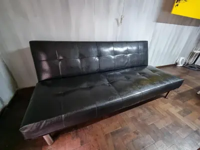a black leather couch sitting in a room at Chacabuco Confort - Bienes Reales in Cordoba