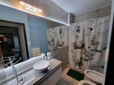a bathroom with a sink and a toilet and a mirror at Chacabuco Confort - Bienes Reales in Cordoba