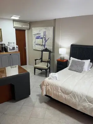 a bedroom with a bed and a chair and a table at Spilimbergo's Home in Cordoba