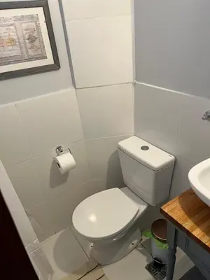 a bathroom with a white toilet and a sink at Spilimbergo's Home in Cordoba