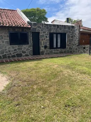 a stone house with a yard in front of it at Spilimbergo's Home in Cordoba
